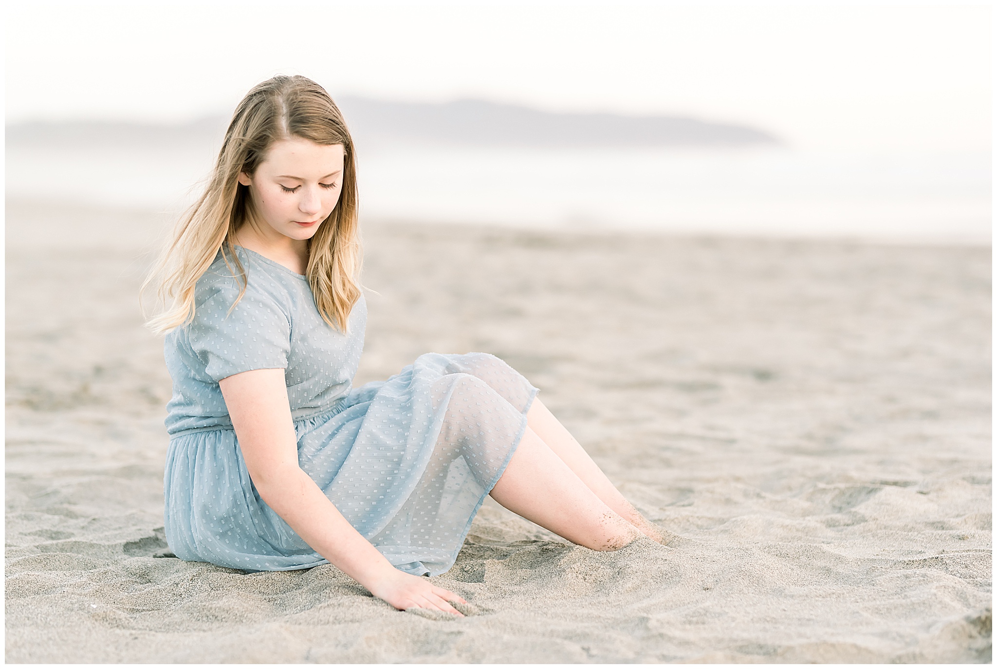 Teenage girl sitting in the sand at the Oregon coast for portraits